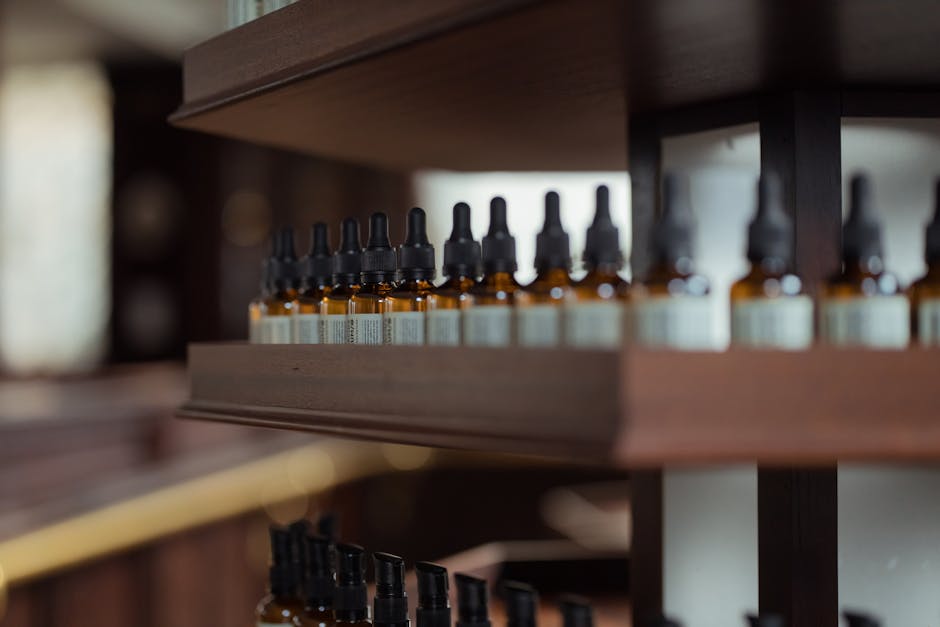 Close-up of essential oil bottle droppers on a wooden shelf in a store setting.